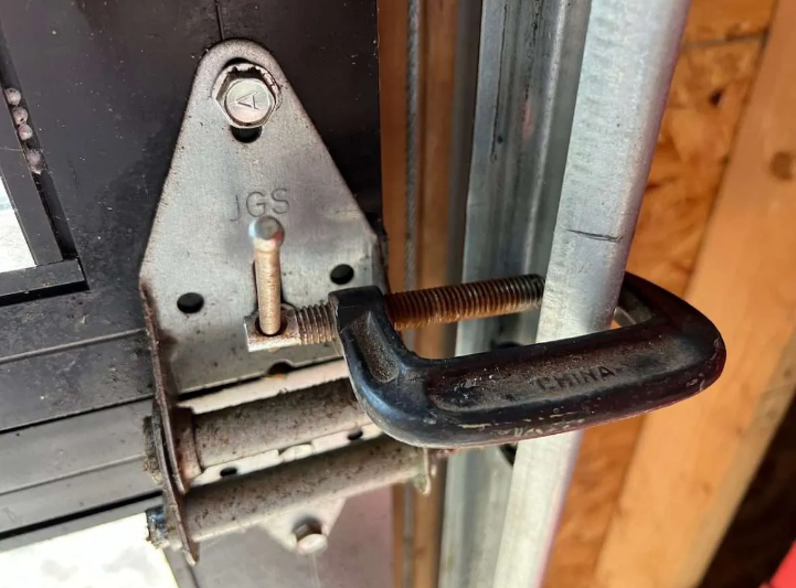 Technician repairing a garage door mechanism to fix a noisy operation in Johnstown, Ohio, ensuring smoother functionality.