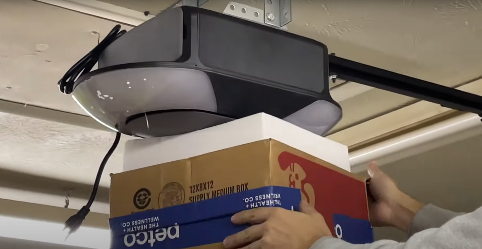 Professional technician installing a new garage door opener with tools and equipment in the background, highlighting expert garage door opener installation services in Johnstown, Ohio.