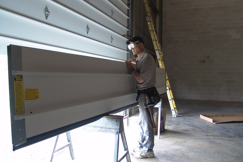 Professional garage door technician in Johnstown, Ohio performing a garage door section replacement