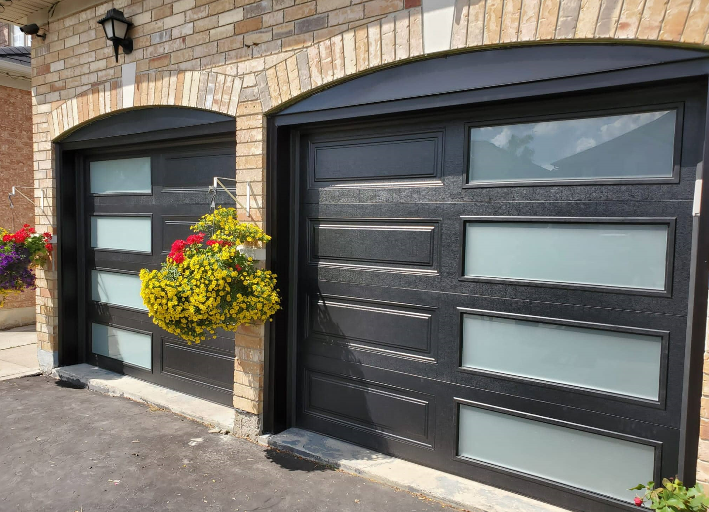 Local garage door repair team servicing a residential garage door in Johnstown, Ohio, including examining, replacing parts, and testing functionality in a neighborhood setting.