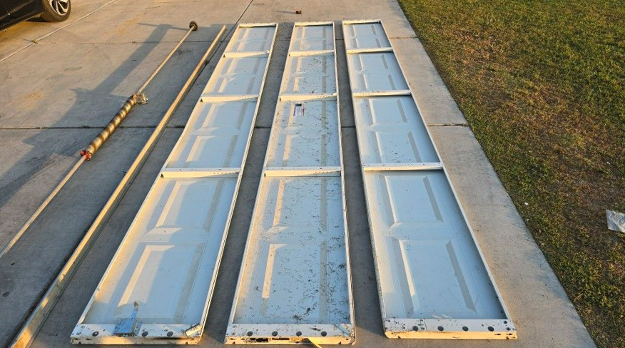 Garage door panel repair in progress by a technician in Johnstown, Ohio, showcasing tools and repair techniques.